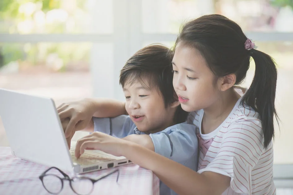 Two girls working together at a laptop