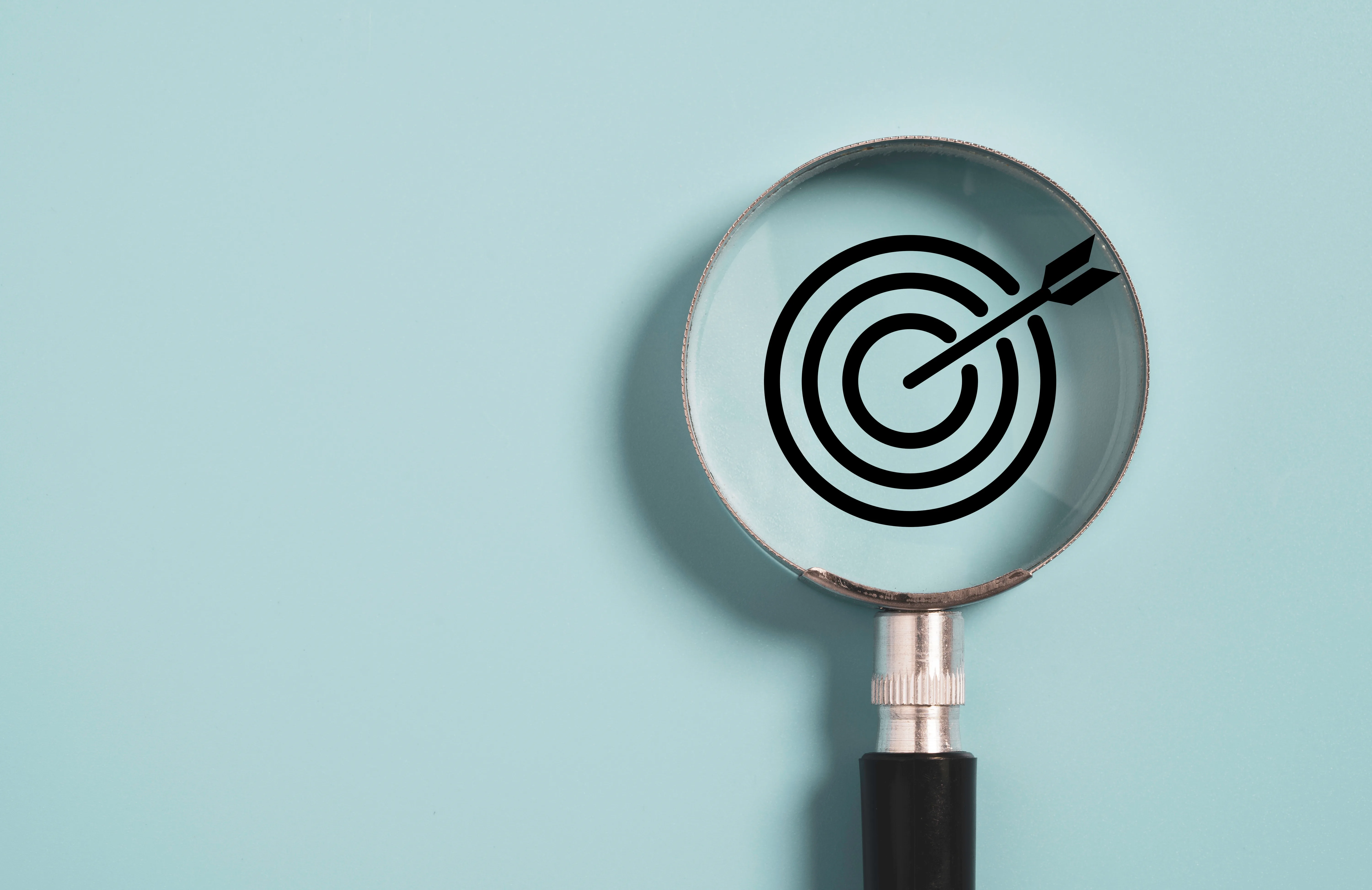 A magnifying glass held over a target symbol