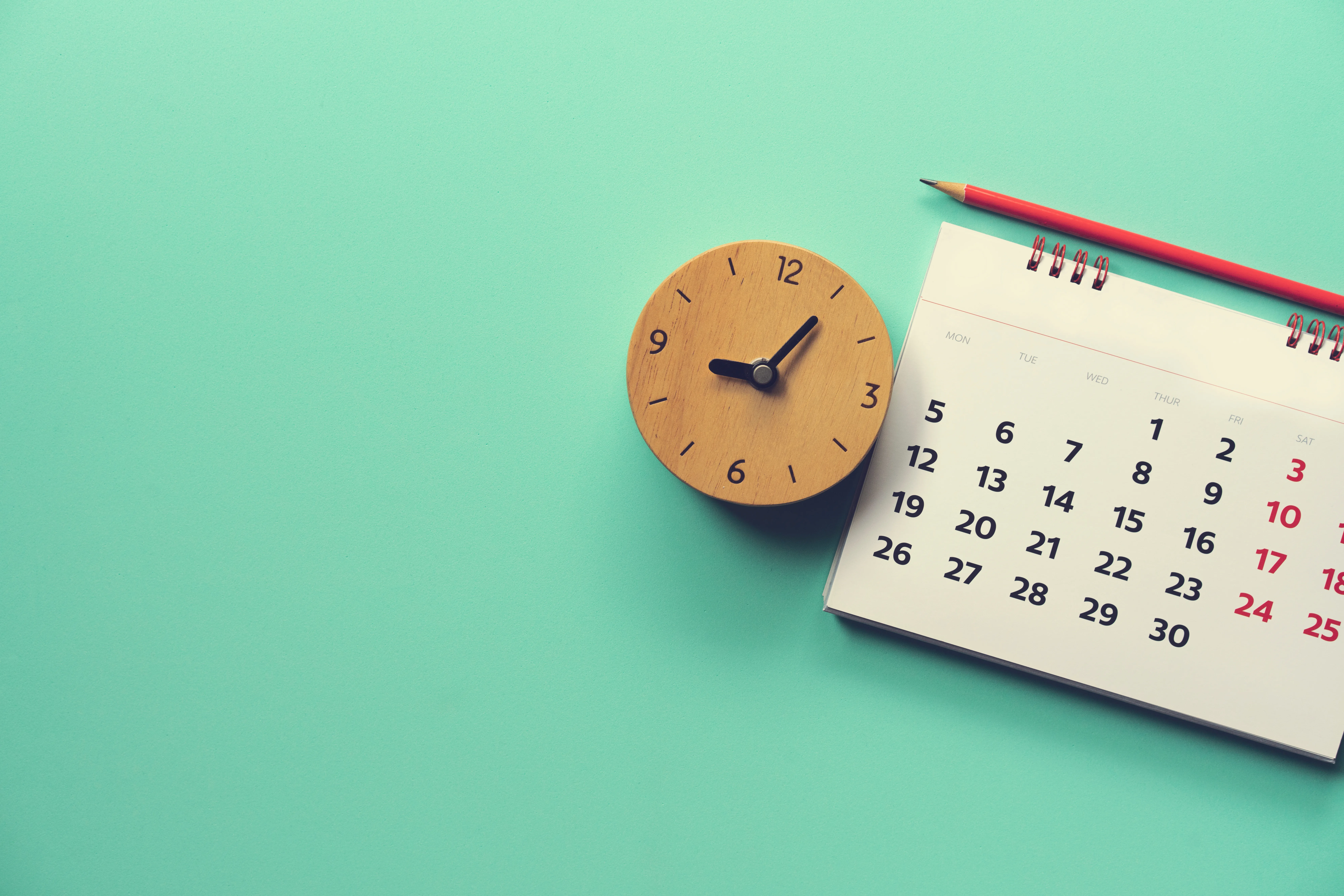 A desk calendar beside a small alarm clock