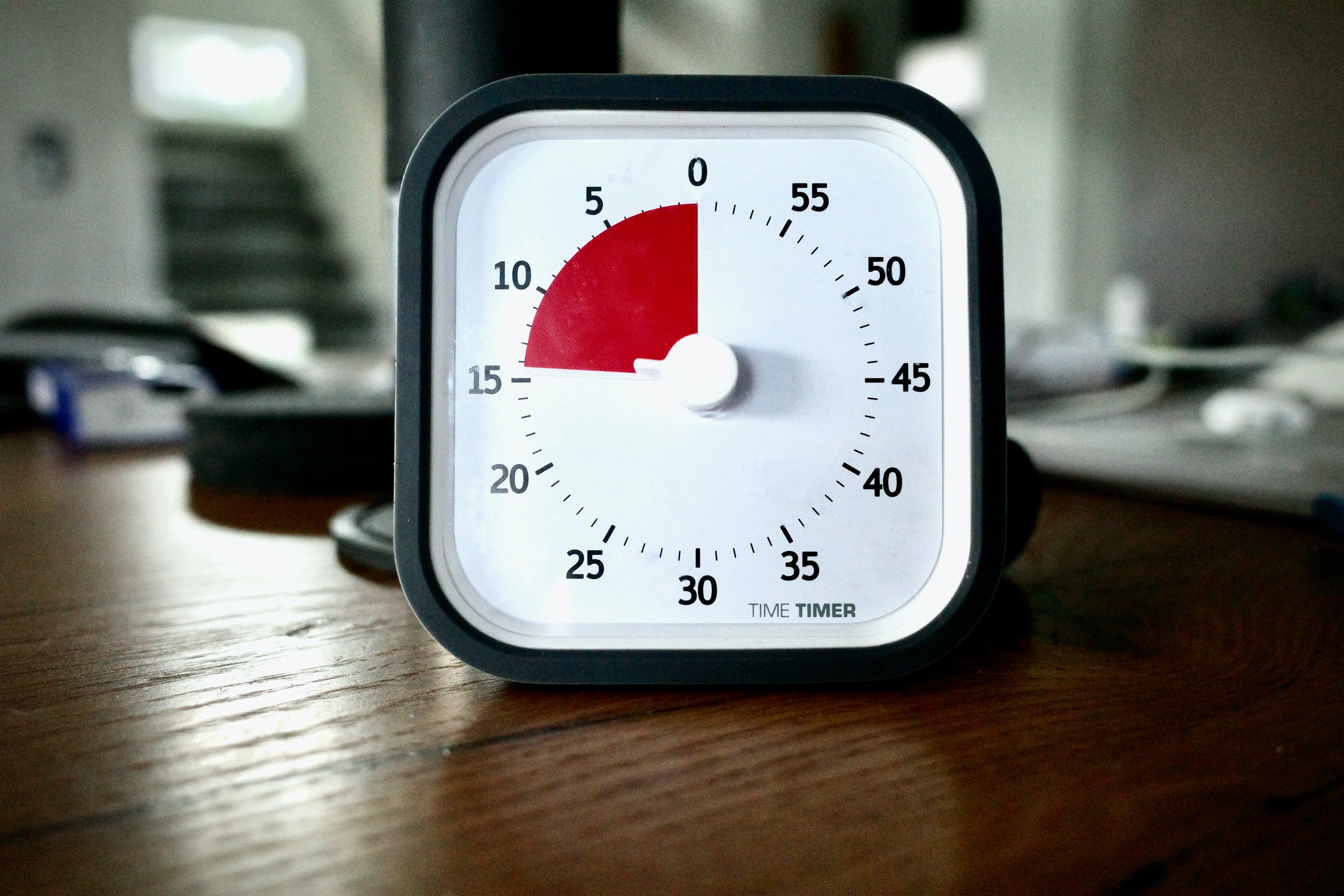A visual countdown timer on a desk, its red segment showing the time remaining
